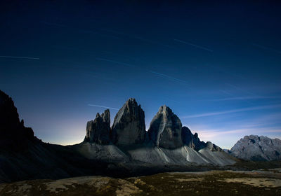 Tre cime lavaredo, drei zinnen silhouette in the night with startrails and blue sky at first light