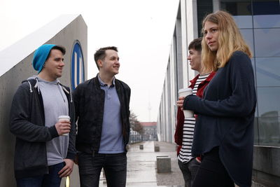 Young friends standing against wall