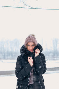 Young woman wearing hat standing in snow