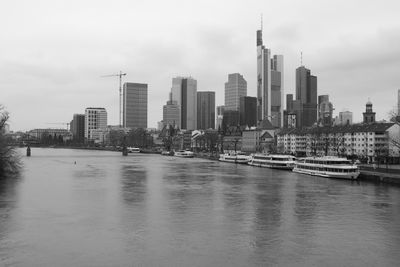 River amidst buildings in city against sky