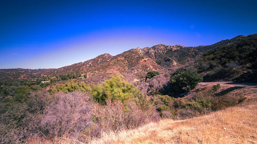 Scenic view of mountains against clear blue sky