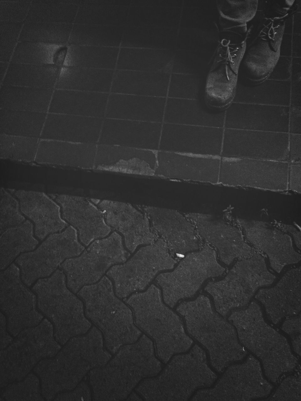 low section, person, cobblestone, street, high angle view, paving stone, shoe, sidewalk, footpath, men, lifestyles, standing, outdoors, human foot, day, unrecognizable person, tiled floor