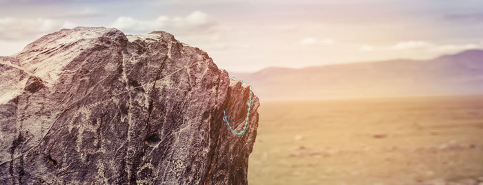 Beige backpack, bottle of water and straw hat on on top of the mountain. active travel concept.