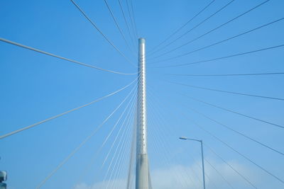 Low angle view of suspension bridge against clear blue sky