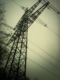 Low angle view of electricity pylon against sky