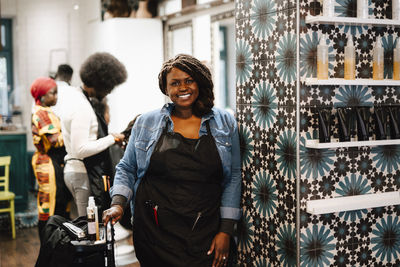 Portrait of smiling mature female hairdresser in barber shop