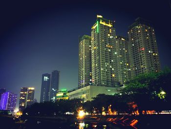 Illuminated cityscape against clear sky at night