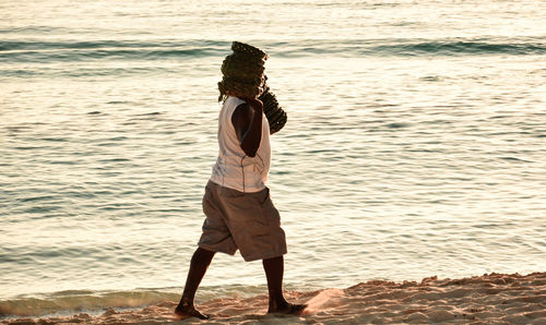 Scenic view of person selling goods on beach against calm sea