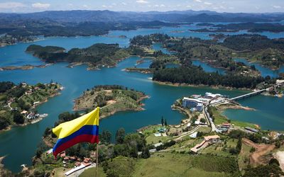 Colombian flag waving against trees and river