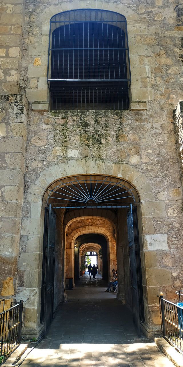 architecture, built structure, arch, direction, the way forward, building, building exterior, day, incidental people, city, real people, outdoors, walking, people, men, wall, wall - building feature, sunlight, entrance, history, alley