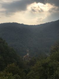 Scenic view of trees and mountains against sky