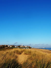 Scenic view of beach against clear blue sky