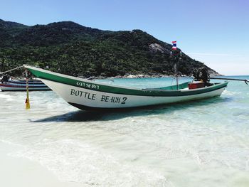 Boat moored on beach against clear sky