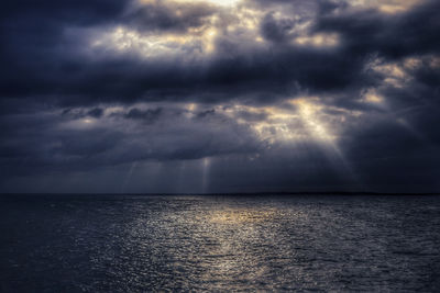 Scenic view of sea against storm clouds