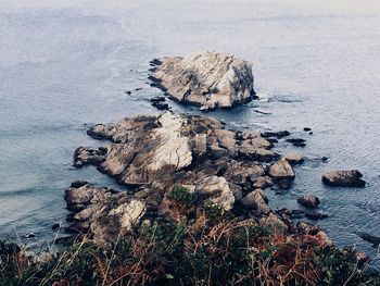 High angle view of rock formation in sea against sky