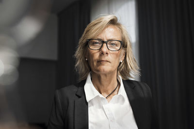 Portrait of confident mature businesswoman in hotel room