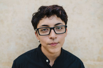 Close up view of a young transgender man looking at camera and smiling.