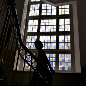 Woman walking on steps against window in building