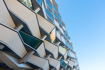 Low angle view of modern building against clear blue sky