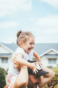 Father holding daughter overhead outdoors