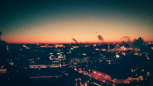 Illuminated cityscape against clear sky at night