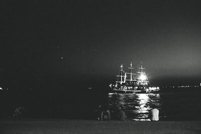 Sailboats sailing in sea against clear sky at night