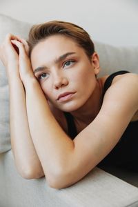 Portrait of young woman lying on bed at home