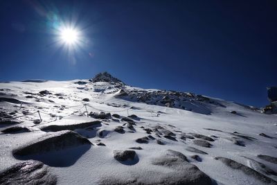 Scenic view of snowcapped mountains against clear blue sky during winter