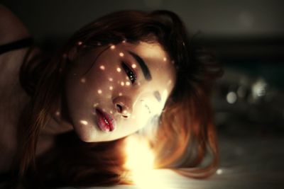 Close-up of young woman by light