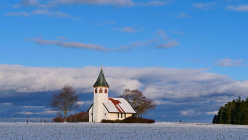 Church by building against sky