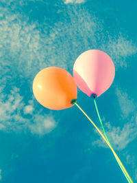 Low angle view of balloons against blue sky