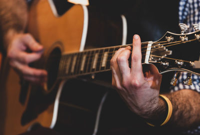 Midsection of man playing guitar