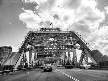 Cars on road against cloudy sky