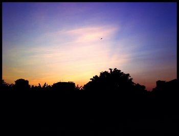 Low angle view of silhouette trees against sky at sunset