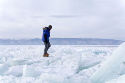 Full length of man standing on snow against sky