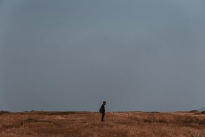 Man standing on field against sky