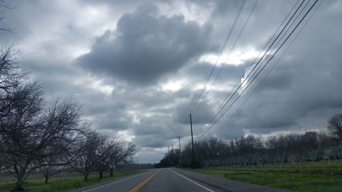 Electricity pylon against cloudy sky