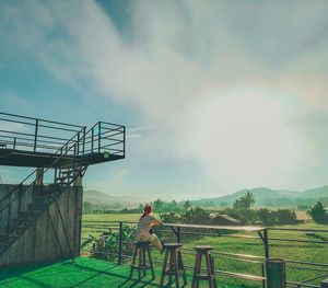 Rear view of man on field against sky