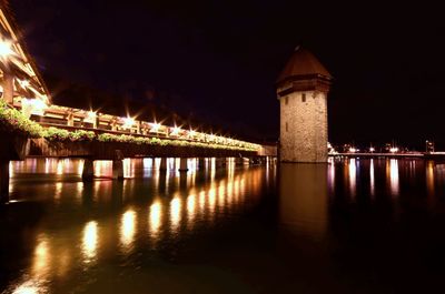 Illuminated buildings at night by lake