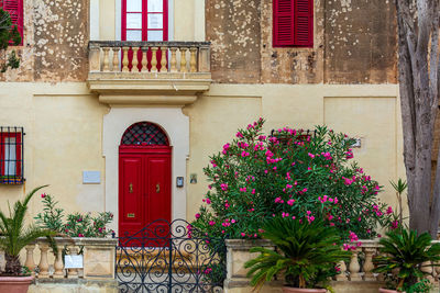 Picturesque house in mdina, malta, with brightly red door and windows' frames and shutters