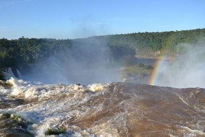 Scenic view of waterfall against sky