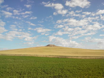 Scenic view of field against cloudy sky