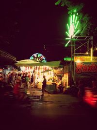 People in illuminated city at night