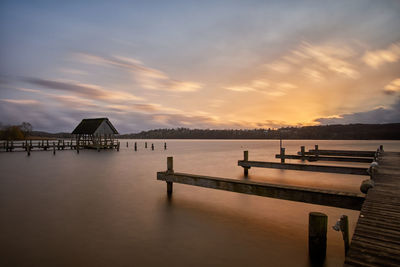 Pier over sea against sky during sunset