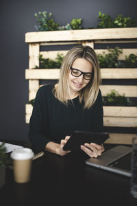 Young woman using phone on table