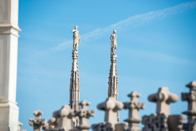 Low angle view of cross against building