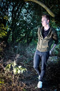 Portrait of young man looking away in forest