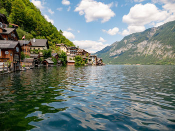 Houses by lake against sky