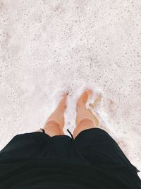 Low section of man standing in water