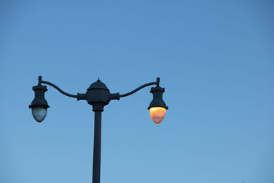 Low angle view of street light against blue sky